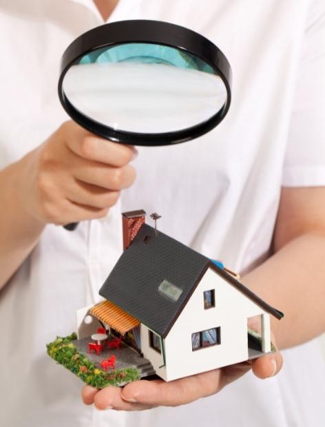 woman holding magnifying glass over a miniature home santa clarita ca